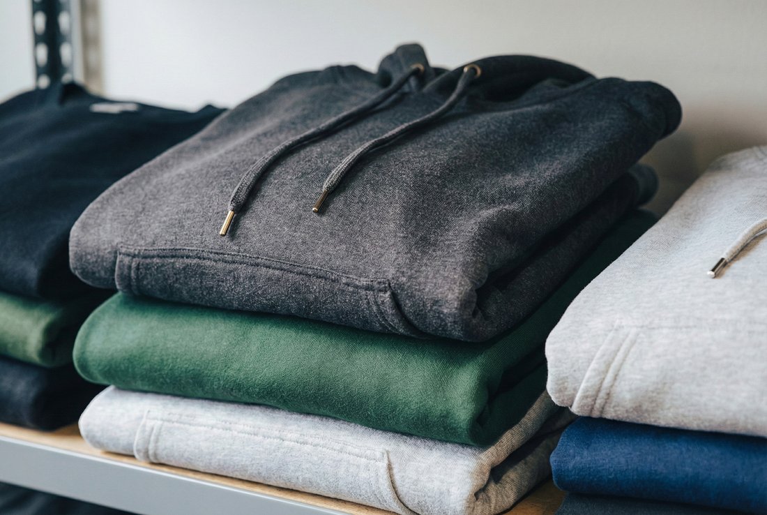 A stack of folded hoodies and sweatshirts ready for custom printing